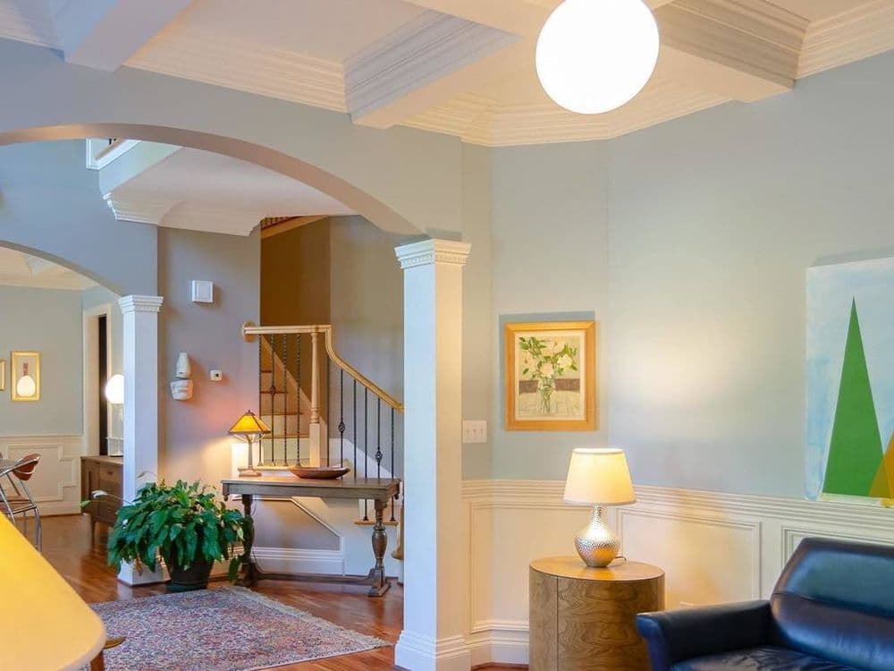 Bright living room with light fixtures, artwork, and cozy furnishings in a spacious layout.