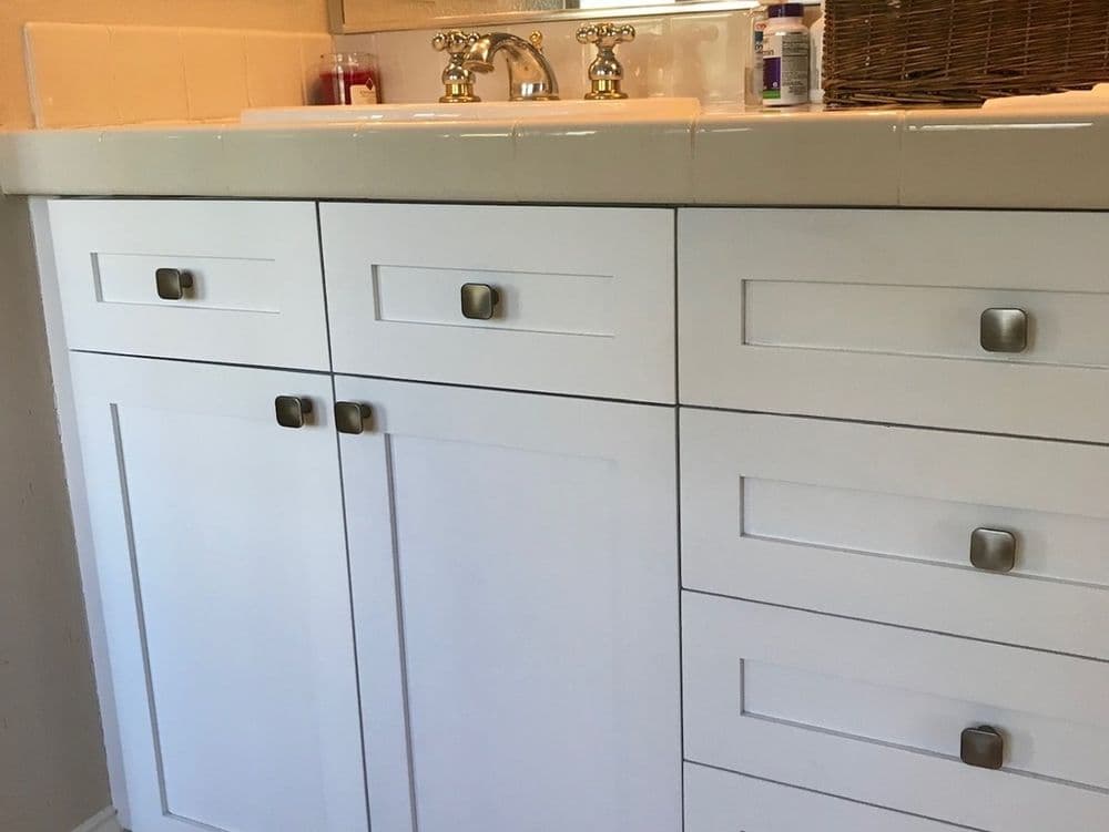 white bathroom cabinet with drawers and a sink faucet in a modern design