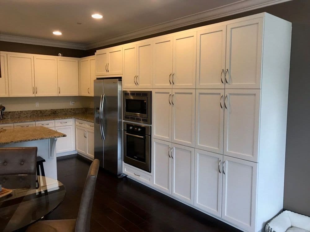 Modern kitchen with white cabinetry, stainless steel appliances, and granite countertops.